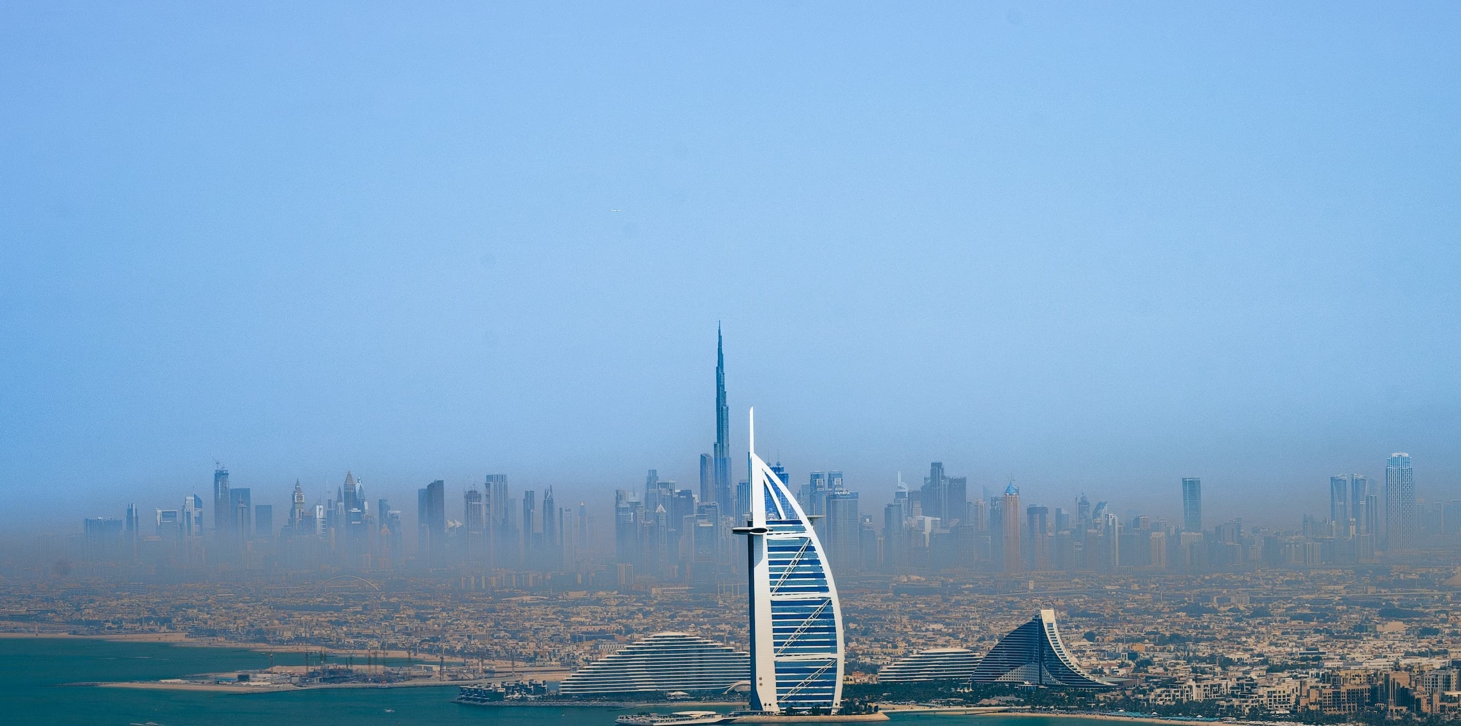 Aerial view of the Dubai coastline with the Burj Al Arab and the Downtown skyline behind it